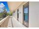 Hallway view of unit's entrance with balcony overlooking lush greenery and blue skies at 700 Melrose Ave # L-23, Winter Park, FL 32789