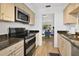 Open kitchen with stainless steel appliances and view of dining and living areas at 700 Melrose Ave # L-23, Winter Park, FL 32789