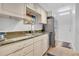 Well-lit kitchen with stainless steel appliances and stone countertops, adjacent to entryway at 700 Melrose Ave # L-23, Winter Park, FL 32789