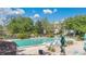 Community pool area featuring lounge chairs, landscaping, and serene views of the surrounding greenery and lake at 700 Melrose Ave # L-23, Winter Park, FL 32789