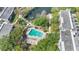 Aerial view of a community pool with plenty of lounge chairs surrounded by lush landscaping near a pond at 700 Melrose Ave # L-23, Winter Park, FL 32789