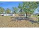 Backyard featuring green grass, mature trees, and a white fence at 7219 Rafanelli Ct, Orlando, FL 32818