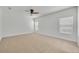 Bright bedroom featuring neutral carpet, large windows for natural light, and a ceiling fan at 7219 Rafanelli Ct, Orlando, FL 32818