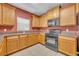 Well-equipped kitchen featuring light wood cabinets, stone countertops, and modern appliances at 7219 Rafanelli Ct, Orlando, FL 32818