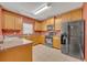 Spacious kitchen featuring wood cabinets, stone countertops, tiled floors, and stainless steel appliances at 7219 Rafanelli Ct, Orlando, FL 32818