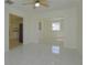 Bright living room featuring tile flooring and an open layout to the kitchen and adjacent room at 7717 Boreas Dr, Orlando, FL 32822