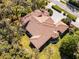 Stunning aerial view of the house with a red tile roof, surrounded by lush landscaping and a brick driveway at 8713 Shimmering Pine Pl, Sanford, FL 32771