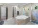 Bright bathroom featuring a tile-surround garden tub nestled between tiled glass showers and ensuite access at 8713 Shimmering Pine Pl, Sanford, FL 32771