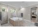 Well-lit bathroom features a soaking tub with tile surround and separate shower, connecting to the main bedroom at 8713 Shimmering Pine Pl, Sanford, FL 32771