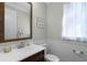 Cozy powder room with a decorative mirror, single vanity, and wainscoting, plus natural light at 8713 Shimmering Pine Pl, Sanford, FL 32771