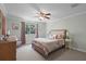 Calming bedroom with neutral walls, a ceiling fan, a plush bed, and a bright window at 8713 Shimmering Pine Pl, Sanford, FL 32771