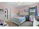 Cozy bedroom with pink walls, a ceiling fan, and natural light from the window at 8713 Shimmering Pine Pl, Sanford, FL 32771