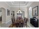 Elegant dining room with a coffered ceiling, decorative chandelier, and stylish decor at 8713 Shimmering Pine Pl, Sanford, FL 32771