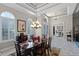 Bright dining room with large windows, decorative lighting, and an ornate front door at 8713 Shimmering Pine Pl, Sanford, FL 32771