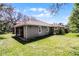 Exterior view of the home with a tile roof, well-manicured lawn, and screened lanai overlooking the backyard at 8713 Shimmering Pine Pl, Sanford, FL 32771