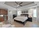 Bedroom showcasing neutral tones, tray ceilings, and a sitting area with hardwood floors at 8713 Shimmering Pine Pl, Sanford, FL 32771