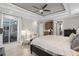 Bedroom with hardwood floors, sliding glass door, tray ceilings, and a sitting area at 8713 Shimmering Pine Pl, Sanford, FL 32771