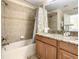 Bathroom features a tub with a shower and a granite counter and vanity at 8845 Candy Palm Rd, Kissimmee, FL 34747