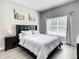 Bedroom featuring a large window, art on the wall and a black headboard at 8845 Candy Palm Rd, Kissimmee, FL 34747