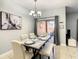 Elegant dining area with marble table set for a meal, complemented by a modern chandelier and decor at 8845 Candy Palm Rd, Kissimmee, FL 34747