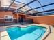 Outdoor pool featuring a safety fence and an enclosed patio area at 8845 Candy Palm Rd, Kissimmee, FL 34747