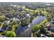 Elevated view of homes bordering a lake and a golf course, enhanced by tree coverage at 9372 Thurloe Pl, Orlando, FL 32827