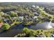 Scenic aerial perspective of homes nestled alongside a lake, complemented by lush green foliage and landscaping at 9372 Thurloe Pl, Orlando, FL 32827