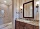 Elegant bathroom with granite countertop, and a walk-in glass shower with detailed tiling at 9372 Thurloe Pl, Orlando, FL 32827