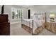 Cozy bedroom featuring a wrought iron bed frame, neutral carpet, and sun-drenched windows at 9372 Thurloe Pl, Orlando, FL 32827