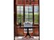 Close up of an elegant dining room table with a view of the landscaped yard outside the window at 9372 Thurloe Pl, Orlando, FL 32827