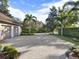 Wide brick-paved driveway leading to a home with a three-car garage and well-maintained landscaping at 9372 Thurloe Pl, Orlando, FL 32827