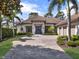 Attractive home with a tile roof, a three-car garage, manicured landscaping, and brick driveway at 9372 Thurloe Pl, Orlando, FL 32827