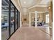 Beautiful foyer view into the dining room, showcasing travertine floors and columns at 9372 Thurloe Pl, Orlando, FL 32827