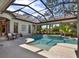 Beautiful screened-in pool area with tiled accents, lush greenery, and ample patio space at 9372 Thurloe Pl, Orlando, FL 32827