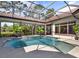 Sparkling pool and spa area with screened enclosure and serene tropical landscaping at 9372 Thurloe Pl, Orlando, FL 32827