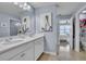 Stylish bathroom featuring double sinks with white cabinets, a large mirror, and contemporary lighting at 9401 La Salle St, Groveland, FL 34736