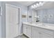 Stylish bathroom featuring double sinks with white cabinets, a large mirror, and contemporary lighting at 9401 La Salle St, Groveland, FL 34736