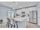 Bright kitchen with white cabinets, stainless steel appliances, quartz countertops, and stylish pendant lighting at 9401 La Salle St, Groveland, FL 34736