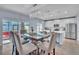 Open-concept kitchen and dining area with modern chandelier, island seating, and stainless steel appliances at 9401 La Salle St, Groveland, FL 34736