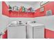 Bright laundry room featuring modern washer and dryer, floating shelf, and charming laundry-themed wall decor at 9401 La Salle St, Groveland, FL 34736