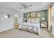 Comfortable main bedroom with plush bedding, green accent wall, adjacent bath, and lots of natural light at 9401 La Salle St, Groveland, FL 34736