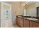 Bathroom vanity featuring double sinks, a large mirror, and tile flooring throughout at 9548 Crown Prince Ln, Windermere, FL 34786