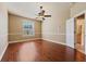 Bedroom featuring hardwood floors, a ceiling fan, and access to the en-suite bathroom at 9548 Crown Prince Ln, Windermere, FL 34786