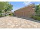 A spacious three-car garage is featured alongside a patterned brick driveway and lush landscaping at 9548 Crown Prince Ln, Windermere, FL 34786