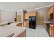 Spacious kitchen featuring tile floors, light cabinets, and an oversized black refrigerator at 9548 Crown Prince Ln, Windermere, FL 34786