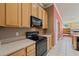 Well-lit kitchen featuring light-colored cabinetry, tile flooring, and a modern black range and microwave at 9548 Crown Prince Ln, Windermere, FL 34786