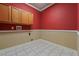 Laundry room showcasing upper cabinets, utility connections and neutral tile flooring at 9548 Crown Prince Ln, Windermere, FL 34786