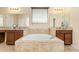 A full bathroom features a soaking tub with dual vanities and fixtures at 11800 Buttonhook Dr, Clermont, FL 34711