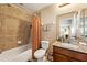 Tiled bathroom with shower, vanity, and commode, featuring neutral tones and a functional layout at 11800 Buttonhook Dr, Clermont, FL 34711