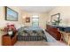 Bedroom with a queen bed, dresser, and decorative wall art, offering a cozy and inviting atmosphere at 11800 Buttonhook Dr, Clermont, FL 34711